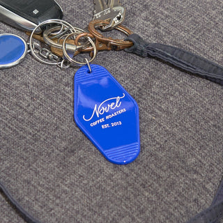 Bright indigo colored motel styled keychain attached to a set of keys